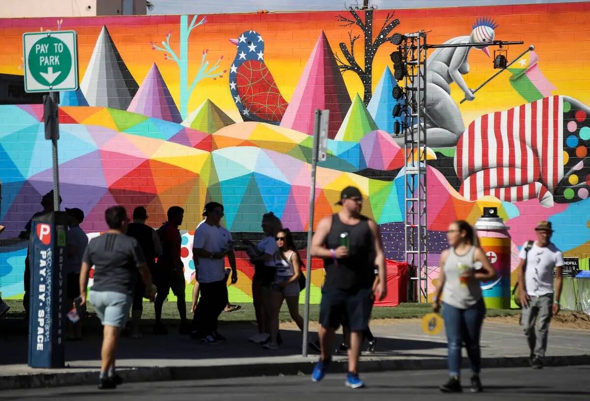 Asistentes pasan junto a un nuevo mural durante el primer día del festival Life is Beautiful e ...