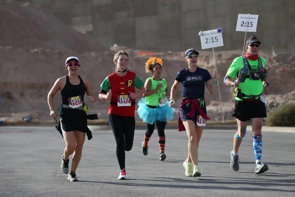 Los corredores esprintan hacia la línea de meta durante el medio maratón de Halloween y las c ...