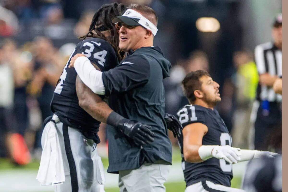 El entrenador de los Raiders Josh McDaniels abraza al running back Brandon Bolden (34) durante ...