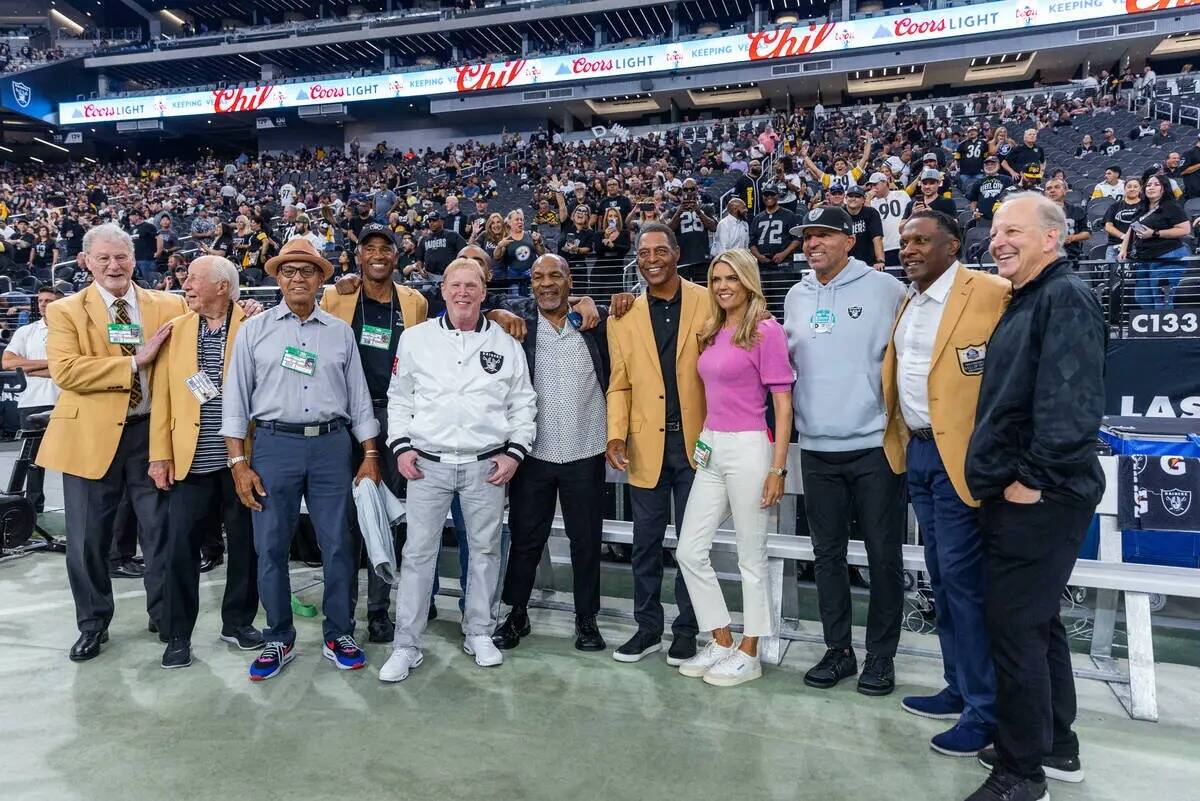 El dueño de los Raiders, Mark Davis, es acompañado por el boxeador Mike Tyson, antiguos alumn ...