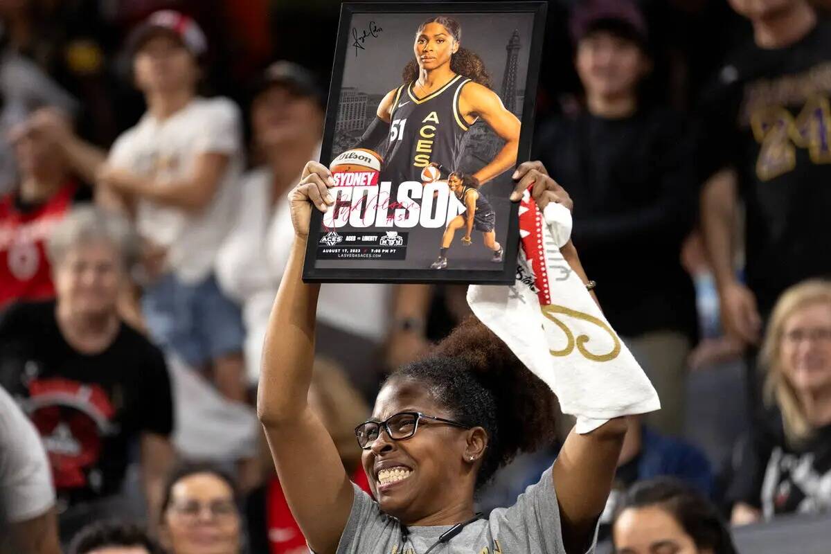 Una fan de Las Vegas Aces sostiene un póster de Sydney Colson durante la segunda parte del pri ...