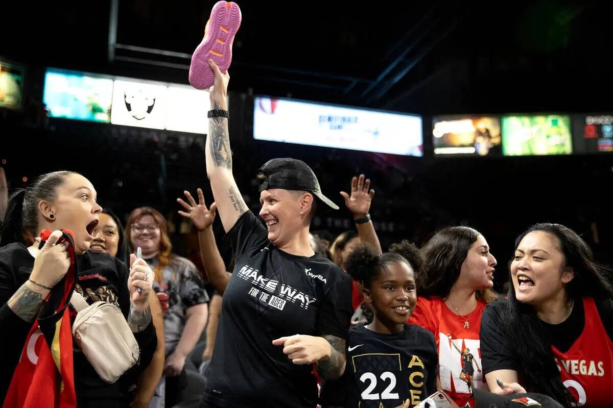 Una fan celebra después de coger una zapatilla firmada después de que las Las Vegas Aces gana ...