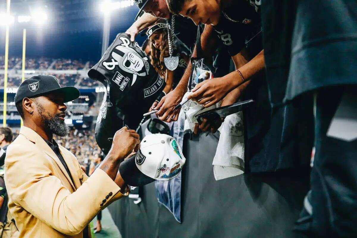 El ex defensa de los Raiders Charles Woodson firma autógrafos para los fans antes del partido ...