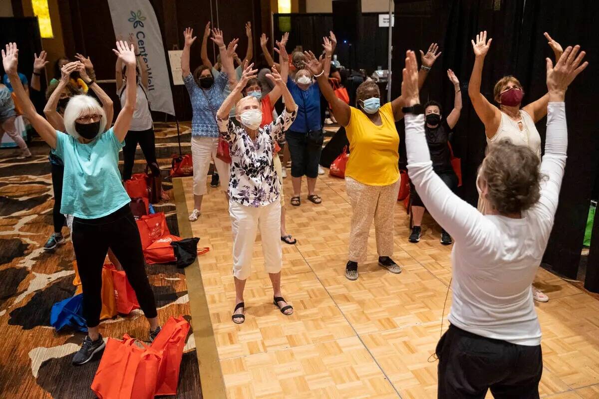 La gente participa en una actividad física en el activo Lounge por CenterWell Atención Primar ...