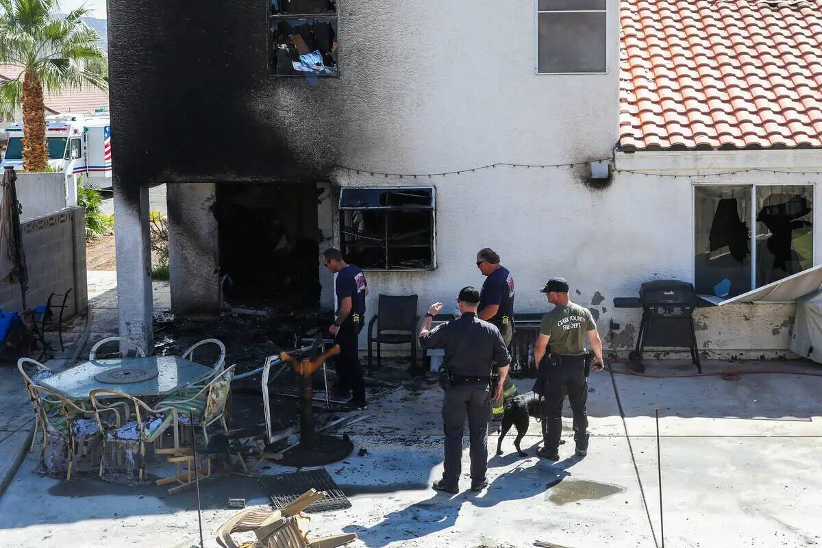 La policía de Henderson y los bomberos investigan alrededor de una casa demolida por un incend ...