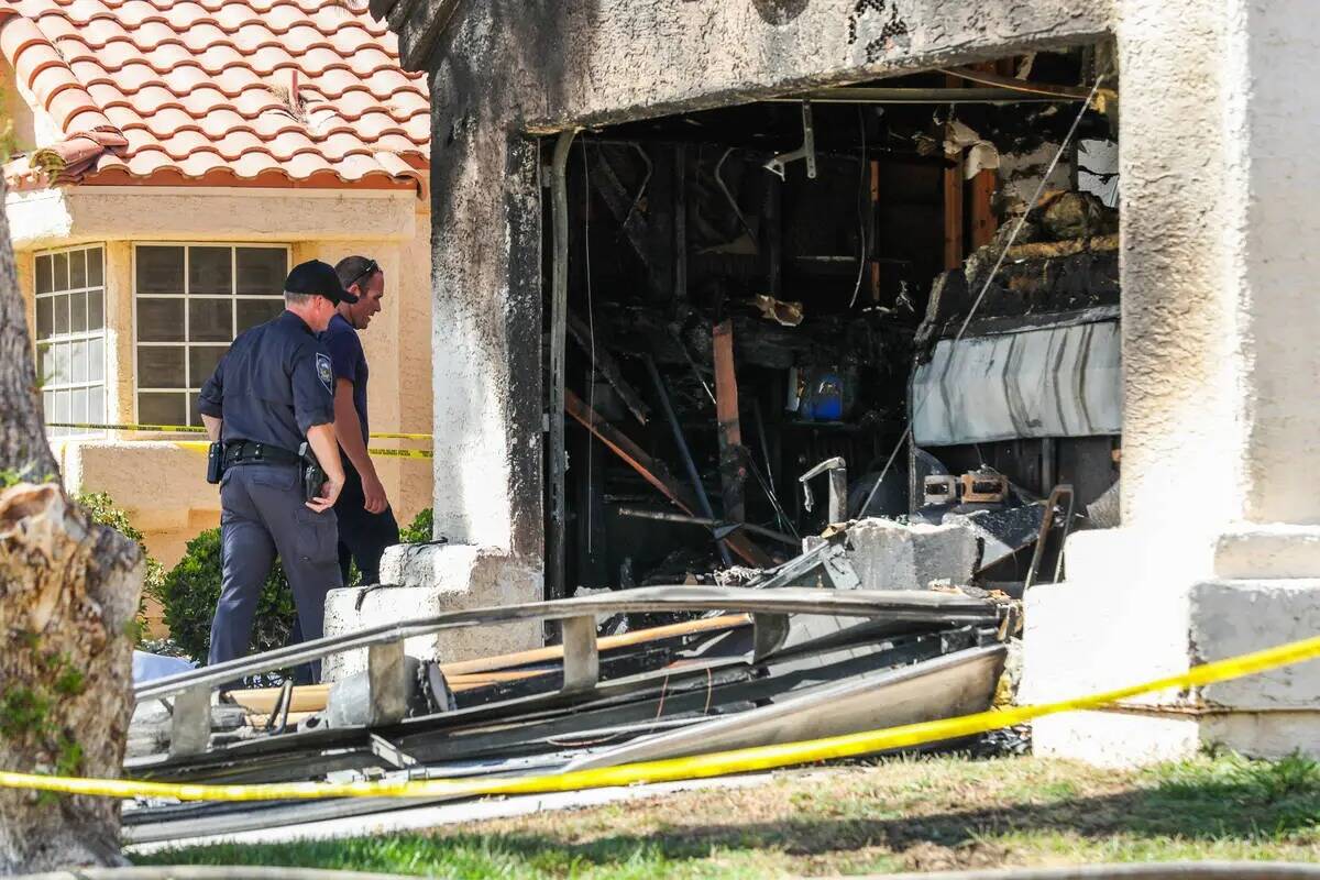 La policía y los bomberos de Henderson investigan el perímetro de una casa demolida tras un i ...