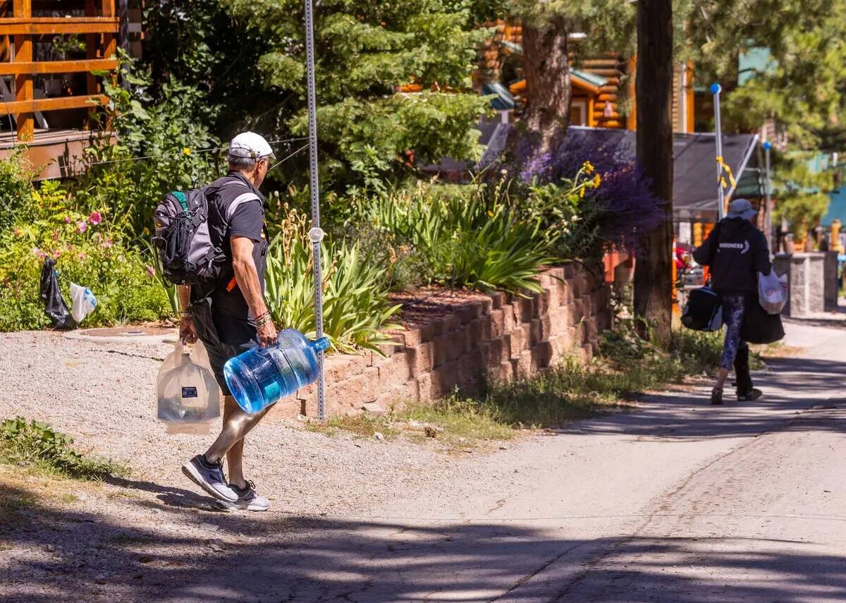Residentes de Old Town cargan jarras de agua en Mount Charleston el miércoles 6 de septiembre ...