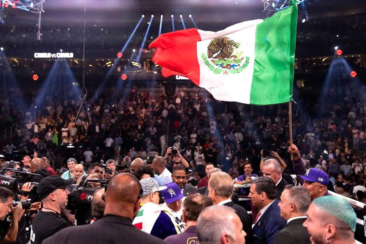 Canelo Álvarez, de México, es rodeado después de ganar un combate de boxeo por el título mu ...