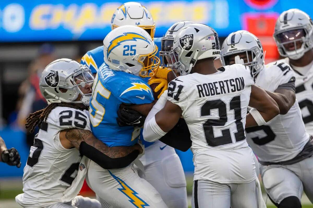 El running back de Los Angeles Chargers Joshua Kelley (25) es tacleado por el safety Tre'von Mo ...