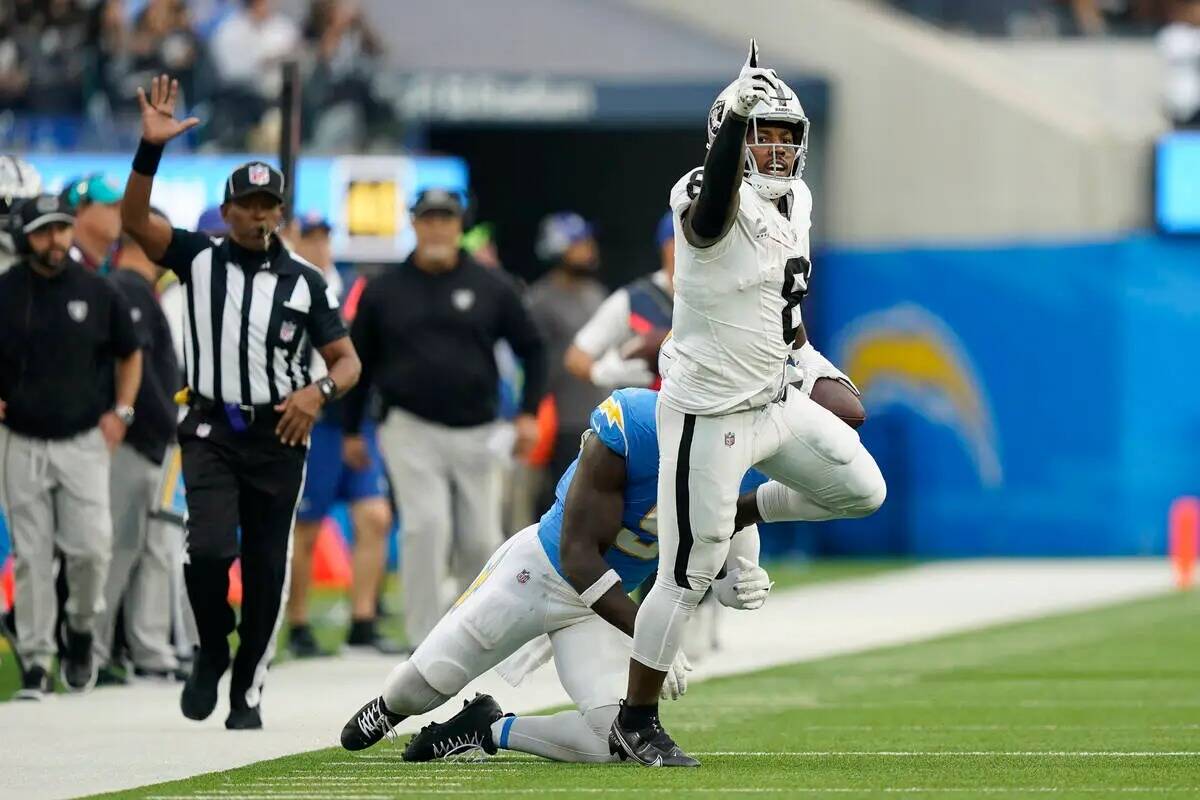 El running back de los Raiders de Las Vegas, Josh Jacobs (8), señala al conseguir un primer do ...