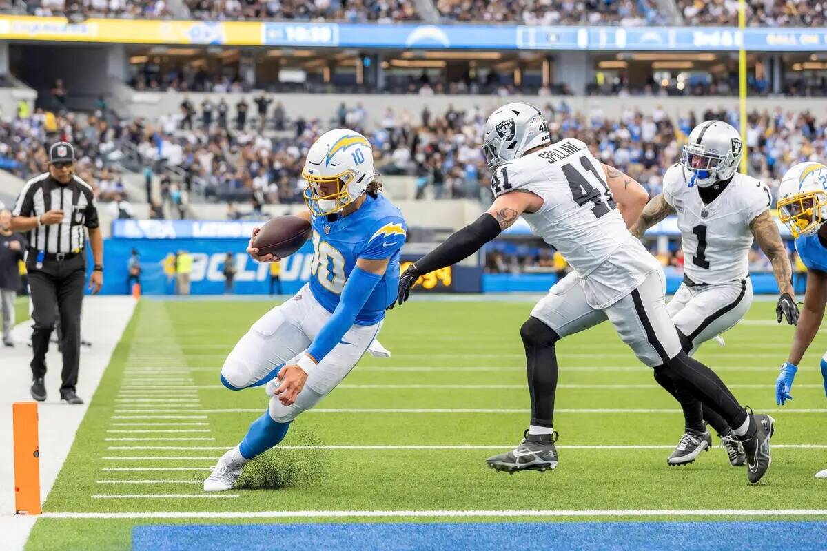 El quarterback de Los Angeles Chargers Justin Herbert (10) corre para un touchdown contra Los V ...
