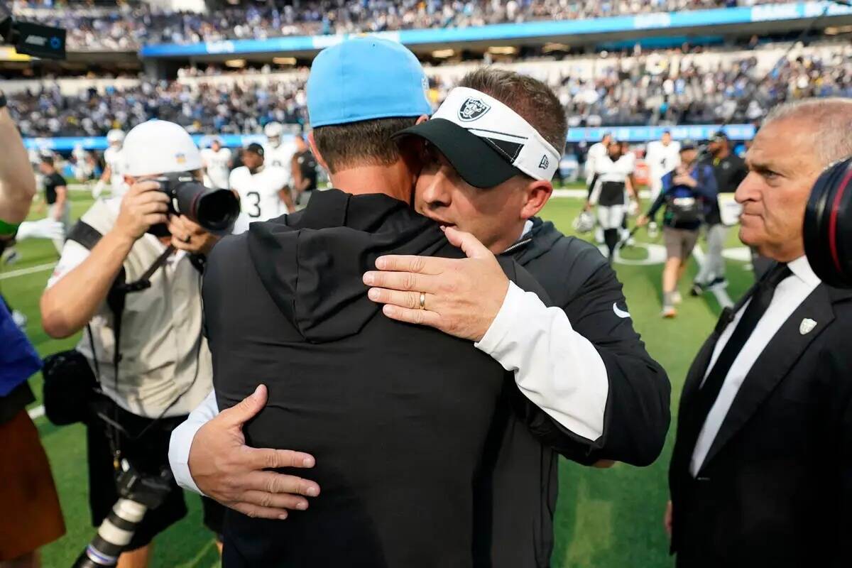 El entrenador en jefe de los Raiders de Las Vegas, Josh McDaniels, a la derecha, abraza al entr ...