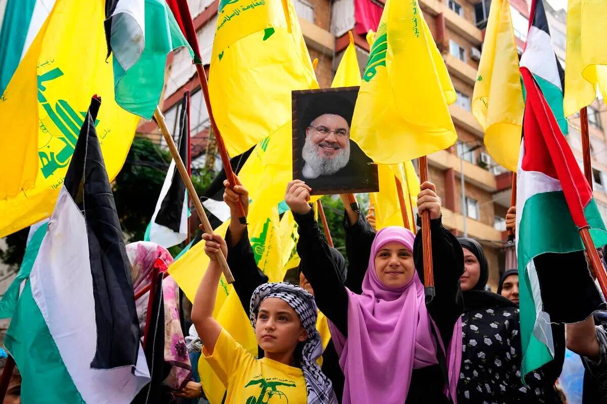 Un partidario de Hezbolá sostiene un retrato del líder de Hezbolá, Sayyed Hassan Nasrallah, ...