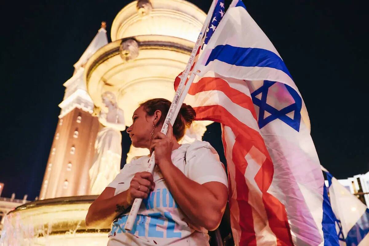 Una persona sostiene una bandera israelí durante una concentración pro-Israel frente al Venet ...