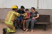 Un bombero israelí da de beber a un niño junto a un sitio alcanzado por un cohete disparado d ...