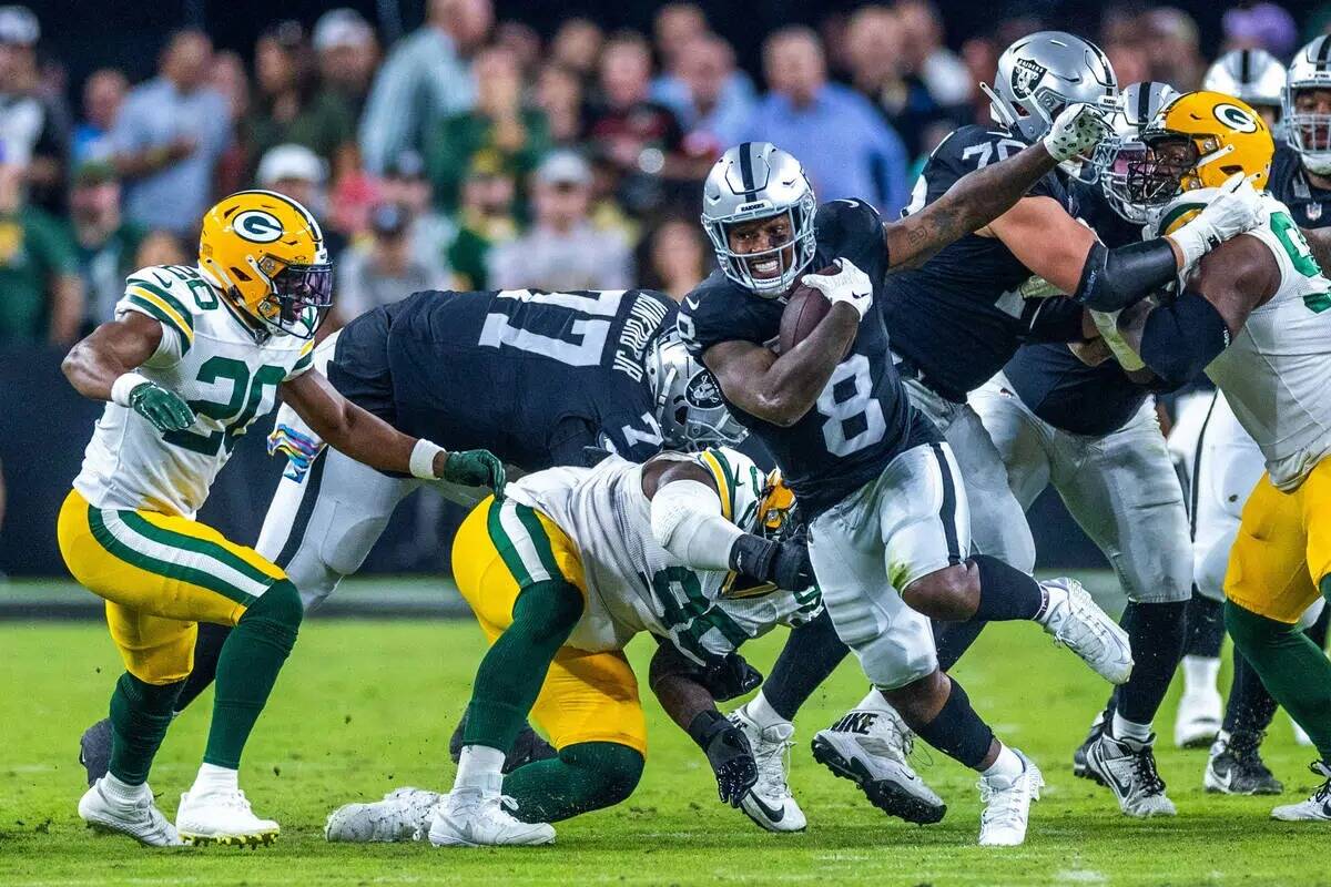 El running back de los Raiders Josh Jacobs (8) se abre paso contra los Green Bay Packers durant ...