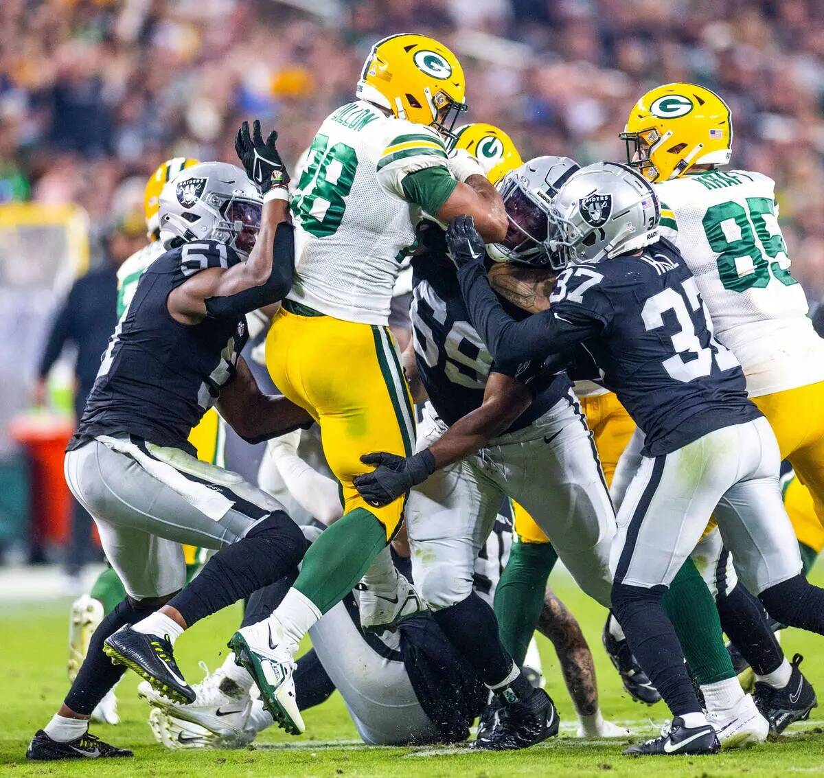 El running back de los Green Bay Packers AJ Dillon (28) es tacleado por el tackle defensivo de ...