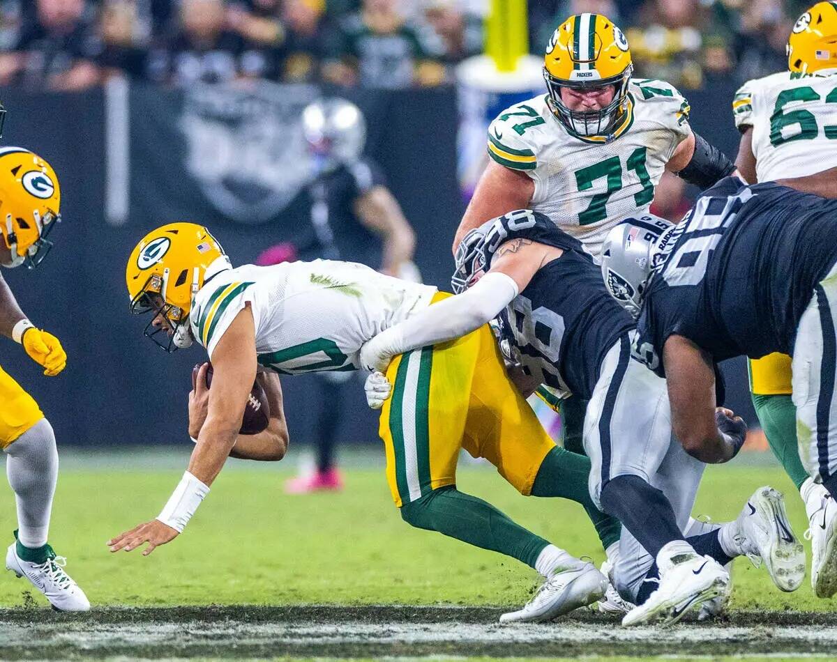 El quarterback de los Green Bay Packers Jordan Love (10) es derribado por el defensive end de l ...