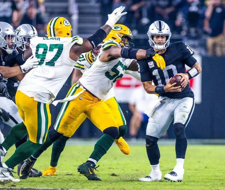 El quarterback de los Raiders Jimmy Garoppolo (10) es presionado por el linebacker de los Green ...