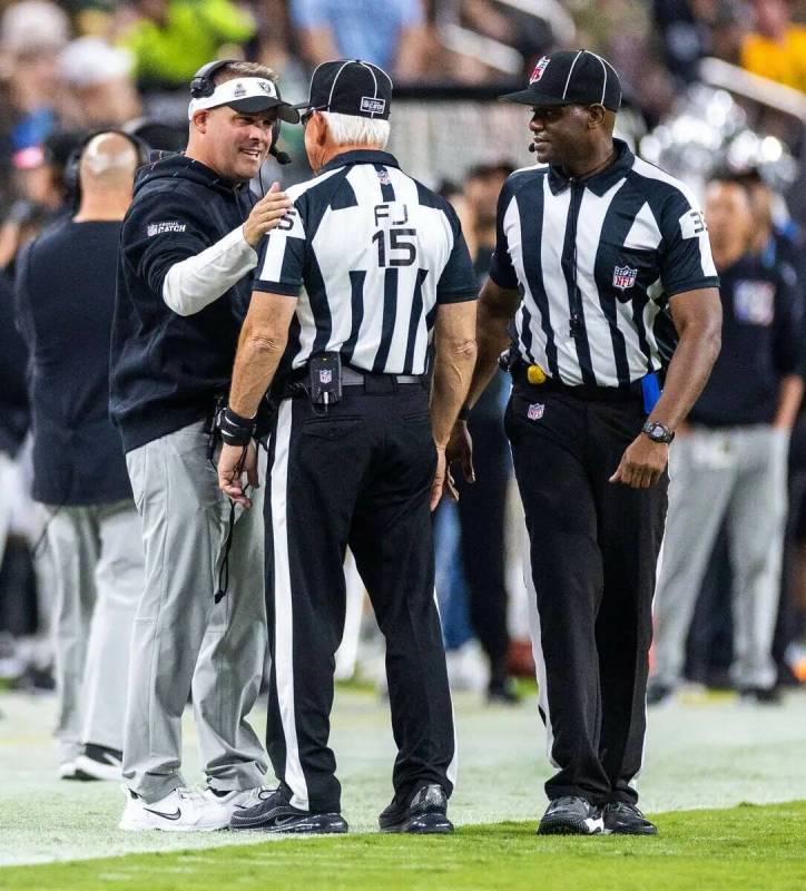 El entrenador de los Ayudantes Josh McDaniels charla con los oficiales en la banda contra los G ...