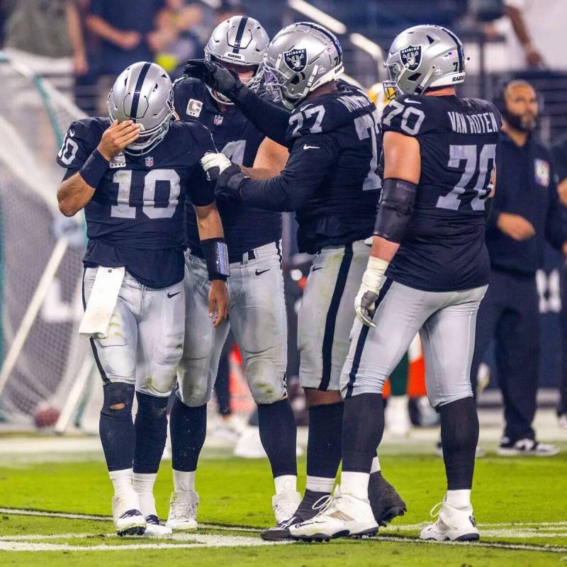 El quarterback de los Raiders Jimmy Garoppolo (10) es revisado por sus compañeros tras un duro ...