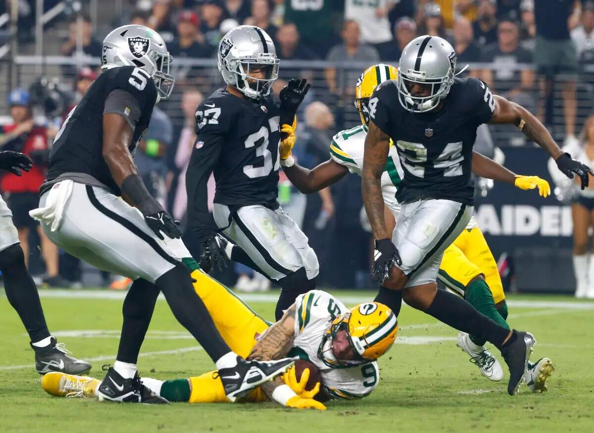 El wide receiver de los Green Bay Packers Christian Watson (9) es derribado por el cornerback d ...