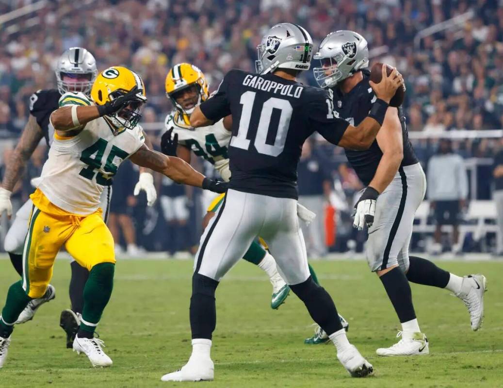 El quarterback de los Raiders Jimmy Garoppolo (10) lanza un pase bajo la presión del linebacke ...