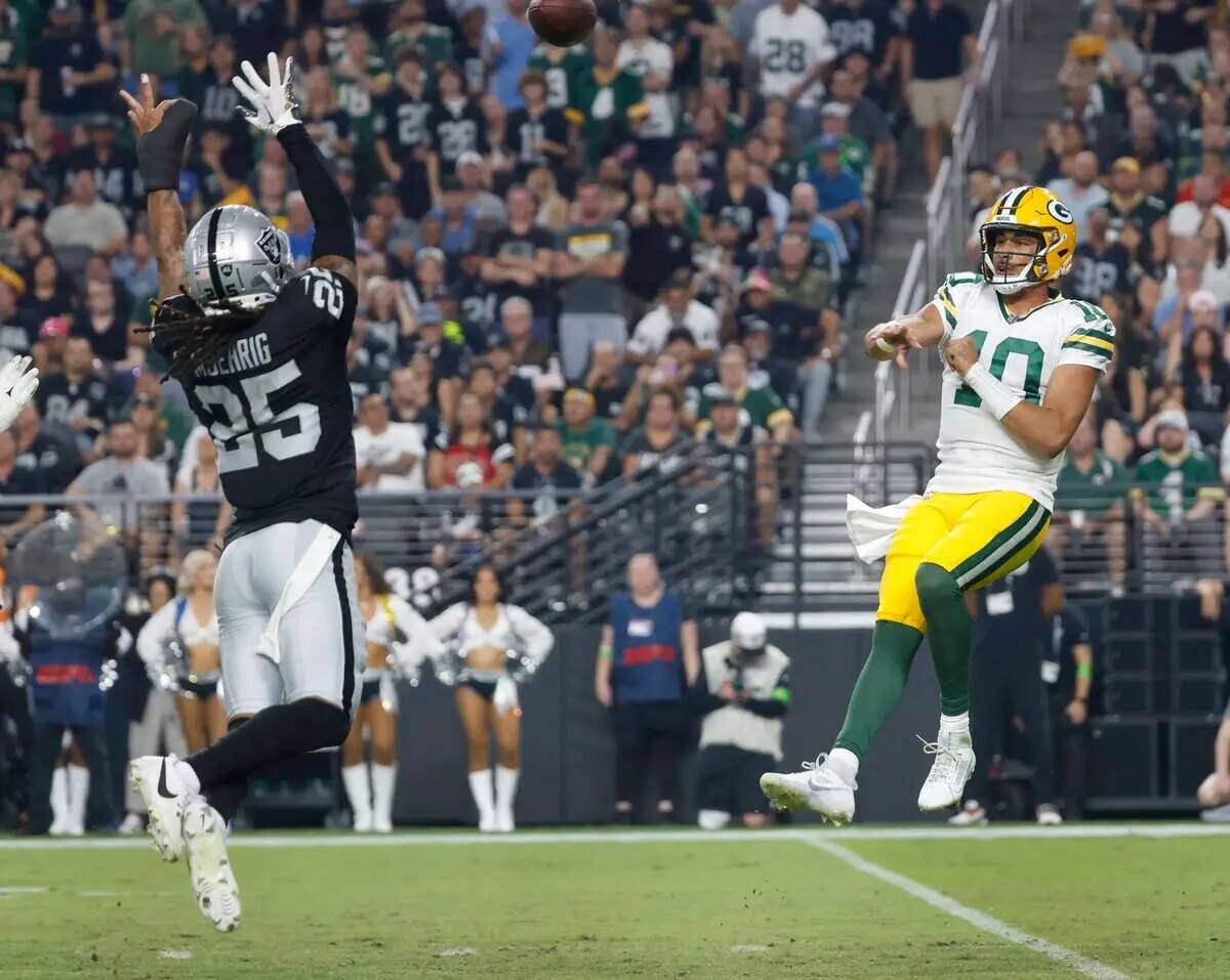 El quarterback de los Green Bay Packers Jordan Love (10) lanza bajo la presión del safety de l ...