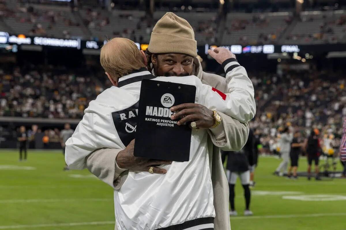 El ex running back de los Raiders Marshawn Lynch abraza al dueño Mark Davis antes de un partid ...