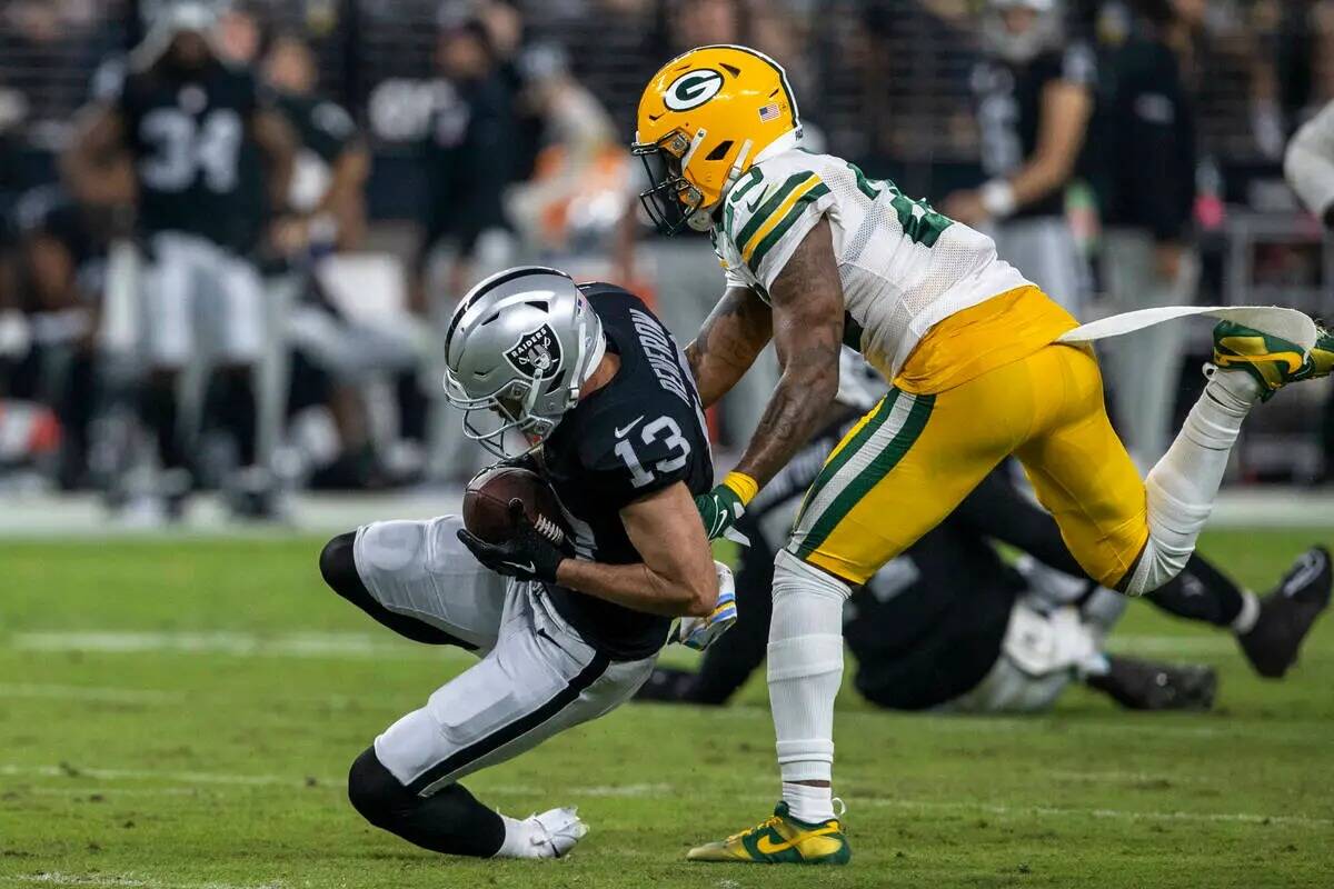 El wide receiver de los Raiders Hunter Renfrow (13) atrapa un balón mientras el cornerback de ...