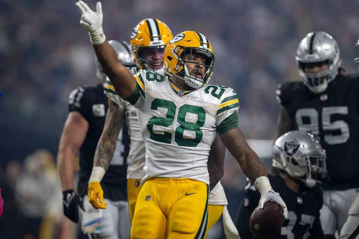 El running back de los Green Bay Packers AJ Dillon (28) señala un primer down contra los Raide ...