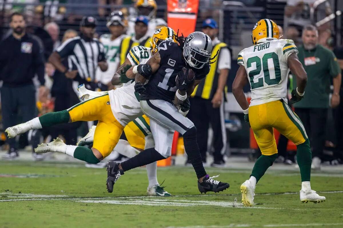 El wide receiver de los Raiders Davante Adams (17) atrapa una pelota ante el linebacker de los ...