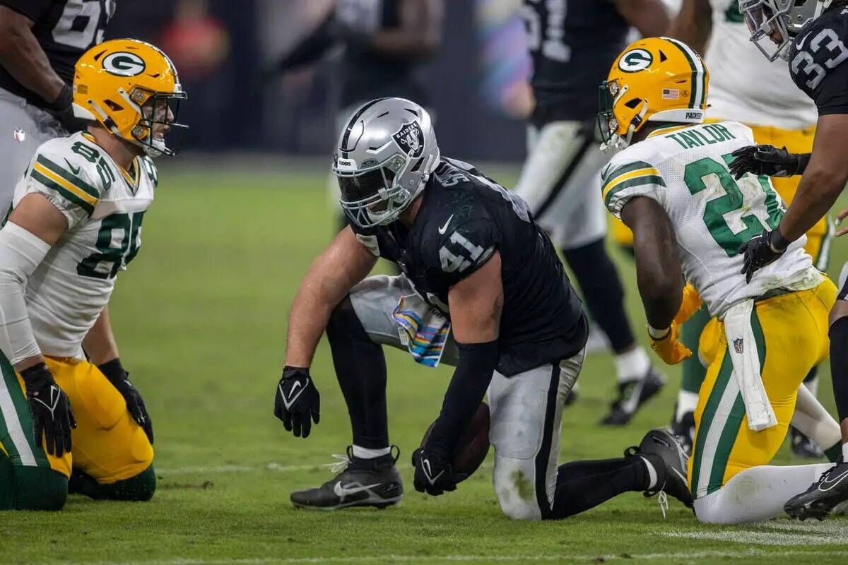 El linebacker de los Raiders Robert Spillane (41) se aferra al fútbol americano después de un ...