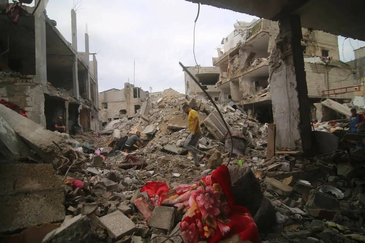 Palestinos inspeccionan los escombros de la familia Abu Helal en el campo de refugiados de Rafa ...