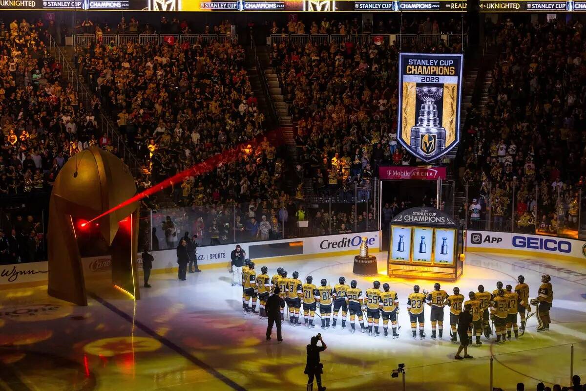 Los jugadores de los Golden Knights se reúnen durante el izado de la bandera del Campeonato de ...