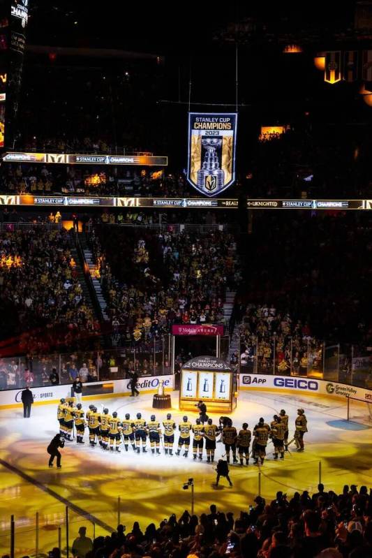 Los jugadores de los Golden Knights se reúnen durante el izado de la bandera del Campeonato de ...