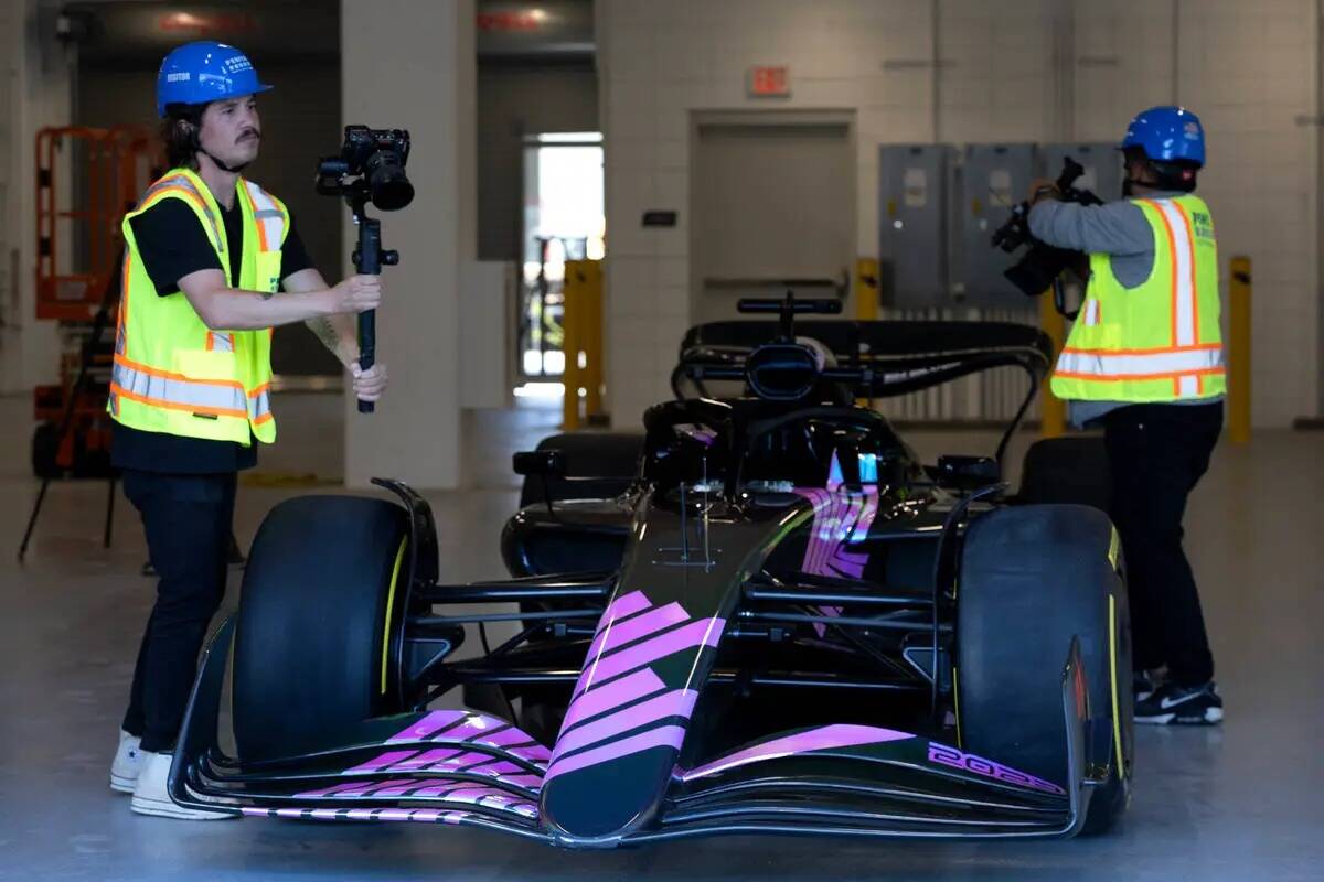 Videógrafos filman un auto de exhibición de la Fórmula Uno durante una conferencia de prensa ...