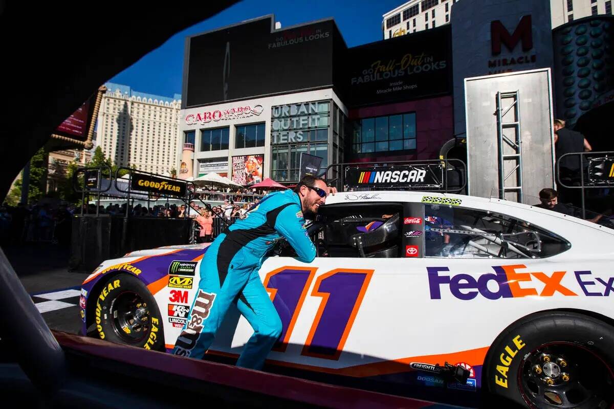 Kyle Busch habla con Denny Hamlin antes de participar en el evento NASCAR America Burnout Boule ...