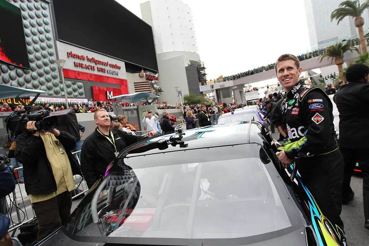 El piloto Carl Edwards sube a su auto durante la Vuelta de la Victoria de la Semana del Campeó ...