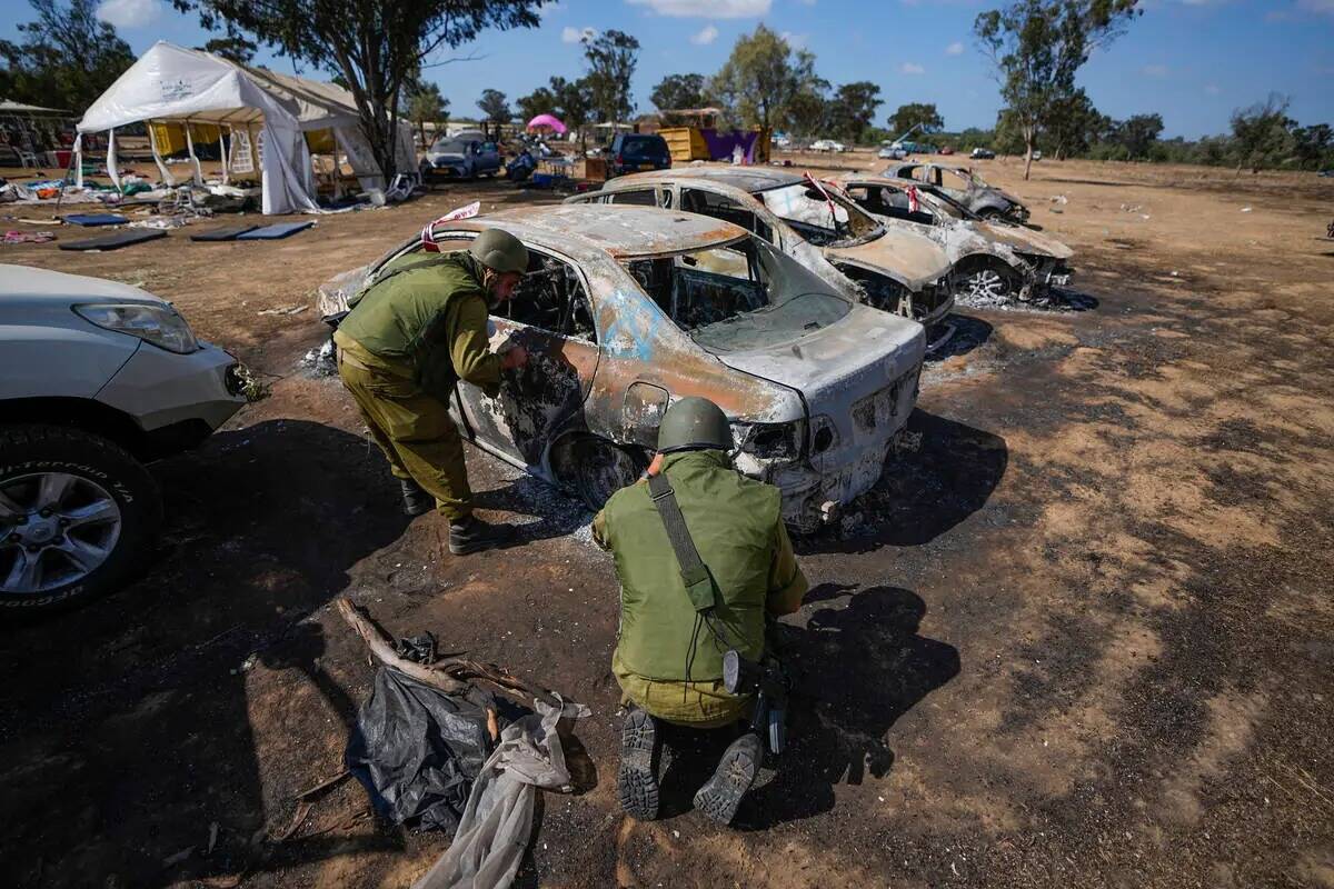 Soldados israelíes inspeccionan el sitio de un festival de música cerca de la frontera con la ...