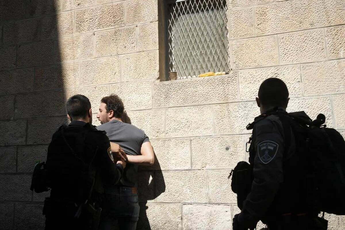 Un policía israelí detiene a un palestino en la Ciudad Vieja de Jerusalén, el viernes 13 de ...