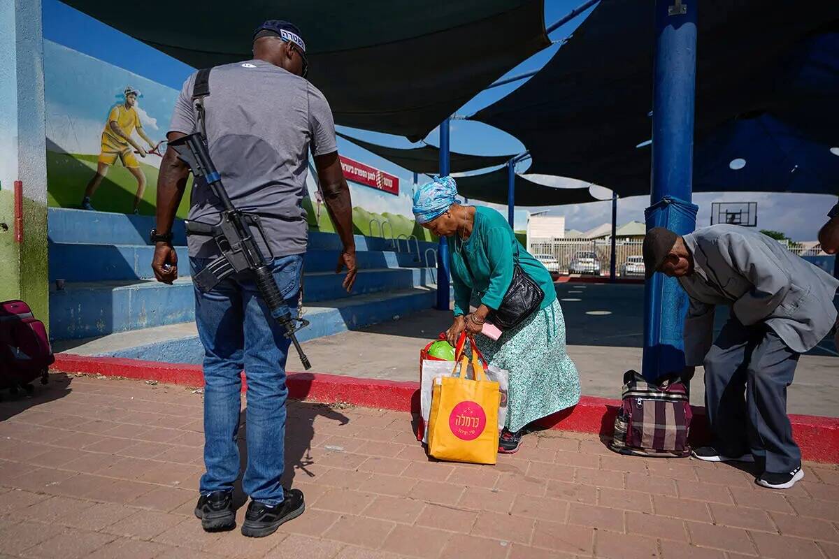 Varios israelíes llevan sus pertenencias mientras evacuan la ciudad de Sderot, en el sur de Is ...