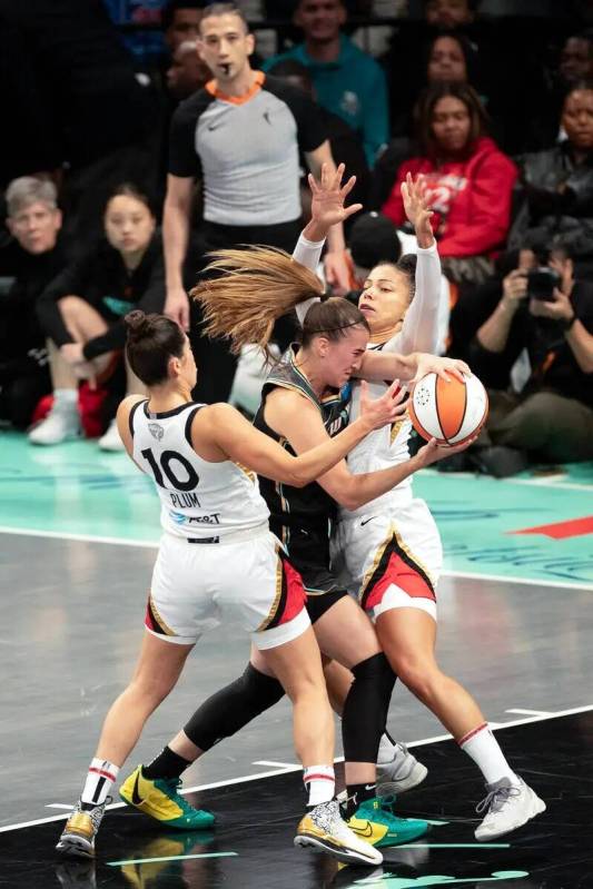 La alera de Las Vegas Aces Alysha Clark (7) y la escolta Kelsey Plum (10) presionan a la escolt ...