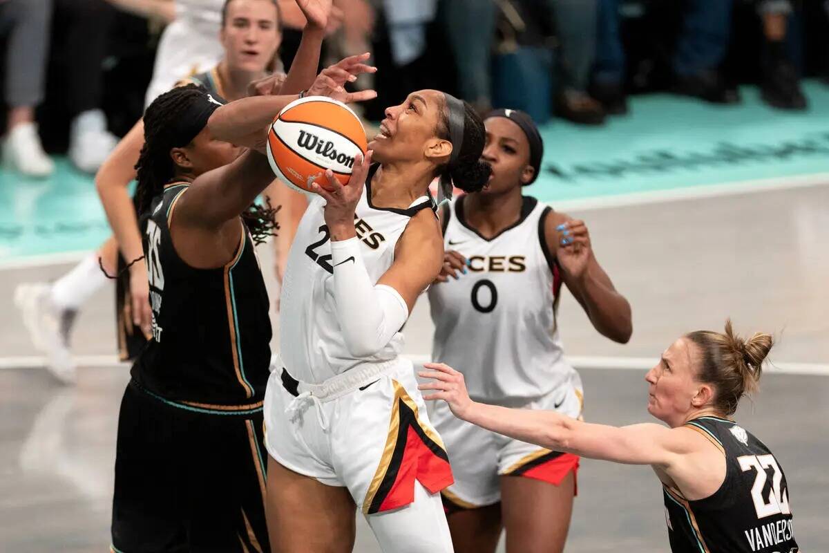 La alera de Las Vegas Aces A'ja Wilson (22) lucha hacia el aro contra la alera de New York Libe ...