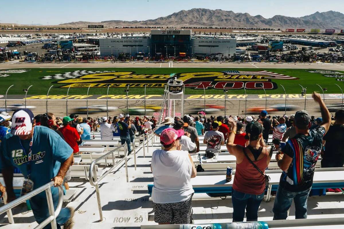 Los autos pasan mientras los fans animan durante la South Point 400 en Las Vegas Motor Speedway ...
