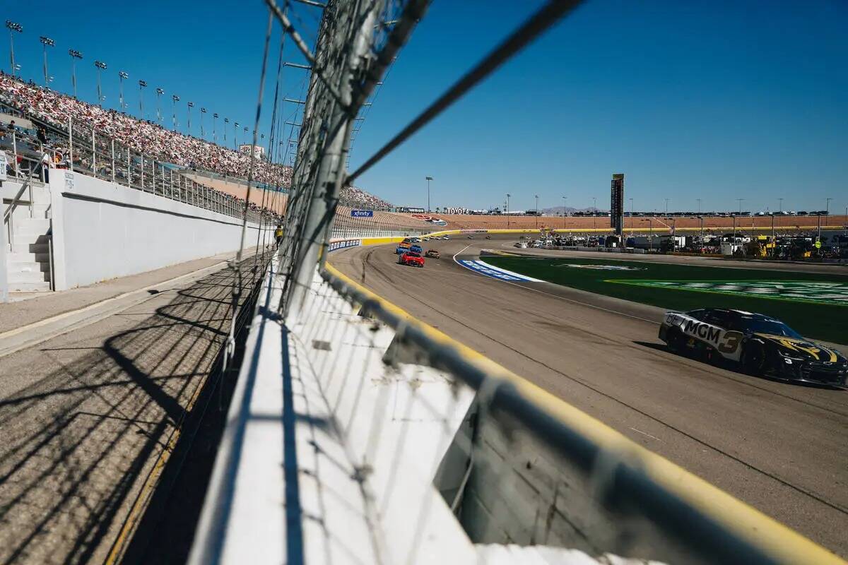 Autos de carrera corren a toda velocidad durante la South Point 400 en Las Vegas Motor Speedway ...