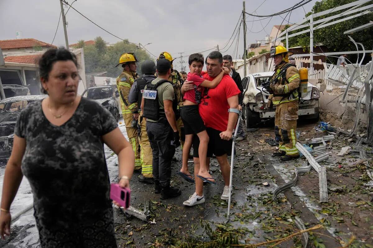 Israelíes evacuan un sitio alcanzado por un cohete disparado desde la Franja de Gaza, en Ashke ...