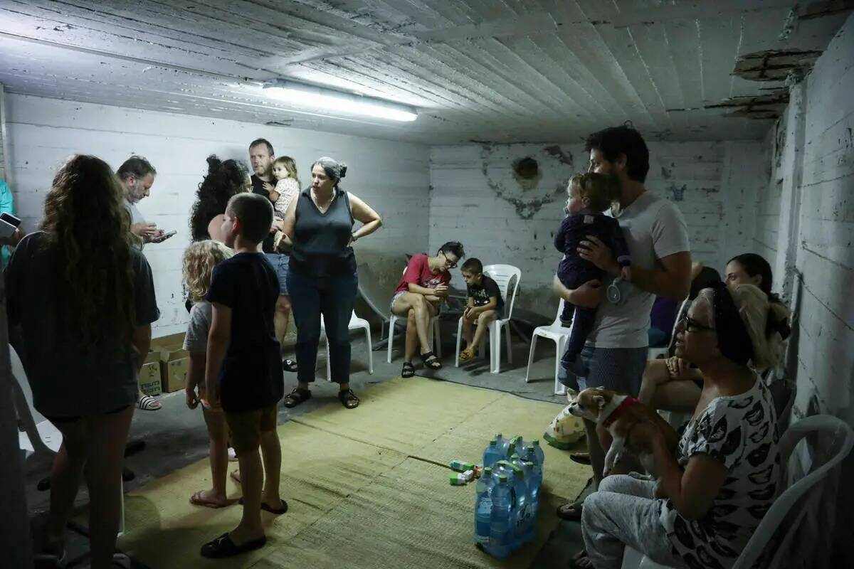Un grupo de israelíes se refugia en una caseta mientras suena una sirena alertando de la llega ...