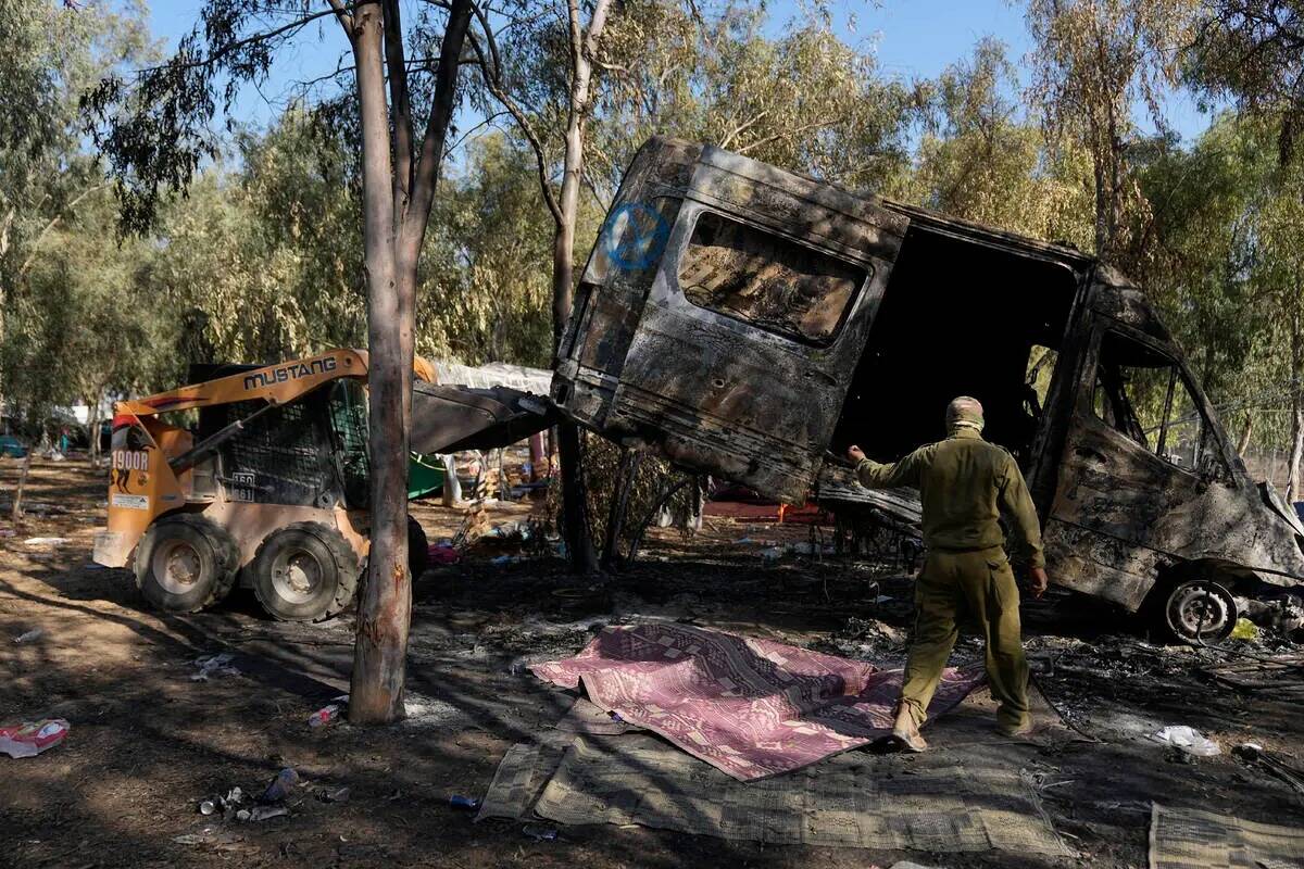 Militares israelíes retiran una furgoneta quemada del sitio de un festival de música cerca de ...