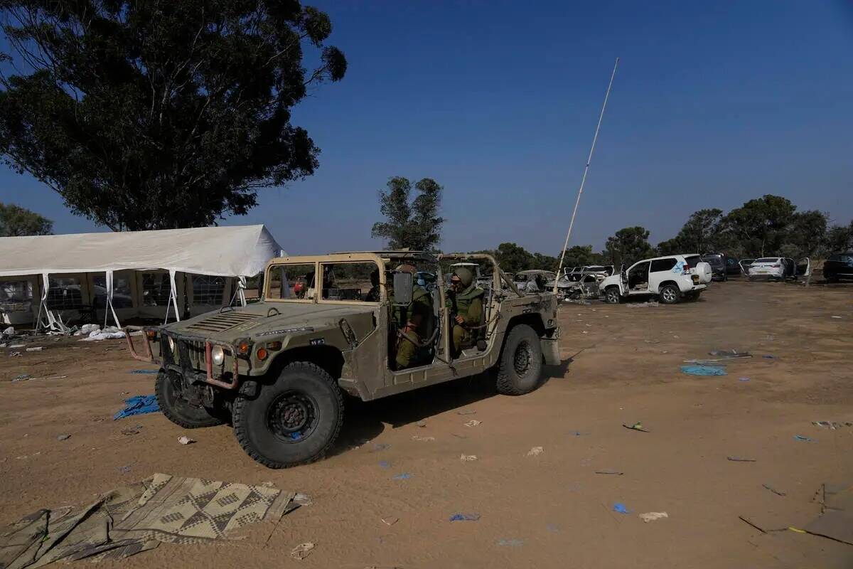 Militares israelíes conducen por el sitio de un festival de música cerca de la frontera con l ...